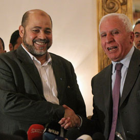 Palestinian Fatah delegation chief Azzam al-Ahmed (R) shakes hands with Hamas deputy leader Mussa Abu Marzuq after a joint press conference in Cairo (getty)