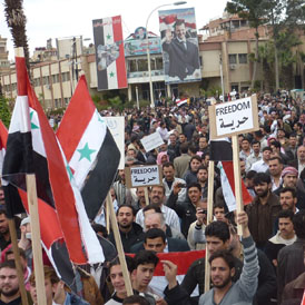 Syria protests: Protesters are seen holding placards during a demonstration in Douma town on April 7 (Reuters)