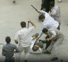 Basij members in civilian clothes attack with batons.