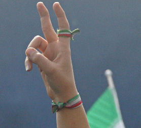 An Iranian woman flashes the V-sign of victory, with the colours of the national flag around her finger and wrist. (Getty)
