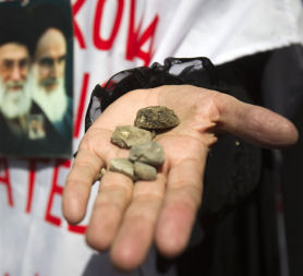 An Iranian woman shows stones in her hand during a rally in Tehran. (Reuters)