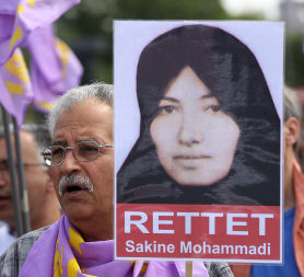 A protester holds a portrait of Sakineh Mohammadi Ashtiani at a protest by Iranian exiles in Germany. (Getty)