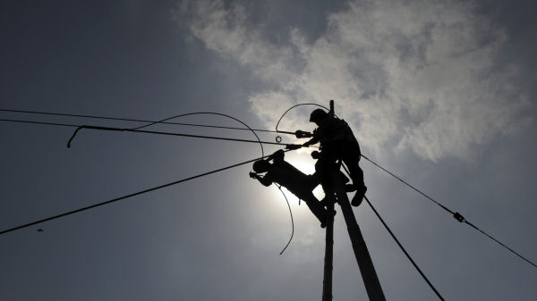 Indian electrical supply workers fix a faulty cable in the outskirts of Kolkata. (Getty)