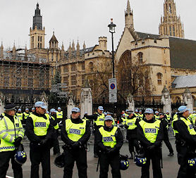  Police officers form a line in front of the Houses of Parliament as student protesters gather nearby (Reuters)