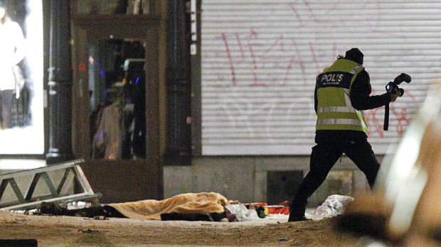 Police forensics expert examines the remains of a suspected suicide bomber in central Stockholm (Reuters)