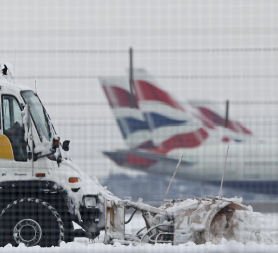 A snow plough is driven by a worker at Heathrow Airport in west London December 19, 2010. Reuters.