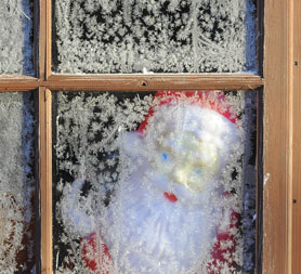 A toy Santa Claus is seen through the frosted window of a garden shed near Boroughbridge (Reuters)