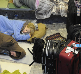Weary travellers at Heathrow Airport (Reuters)