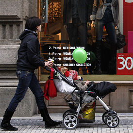 A woman pushes a pram past sale signs (Reuters)