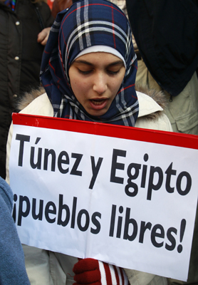 Middle East protests: woman holds up placard calling for freedom in Egypt and Tunisia. 