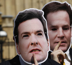 David Cameron, Eric Pickles, George Osborne and Nick Clegg depicted by masks. (Reuters)