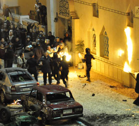 Egyptian riot police attempt to put out fire started by Christians outside a mosque in Alexandria following a church bombing which killed 21. (Reuters)