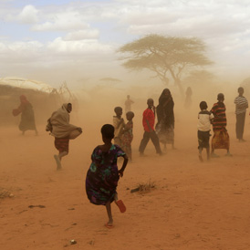 Newly-arrived refugees run away from a cloud of dust at the Dagahaley refugee camp in Dadaab (Reuters)