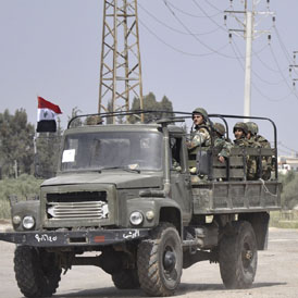 Syrian army vehicles leave the southern town of Deraa (Reuters)