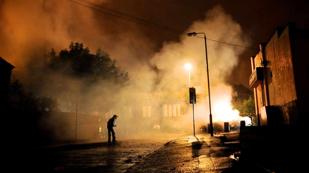 A protester is sihouetted in the flames of East Belfast (Getty).