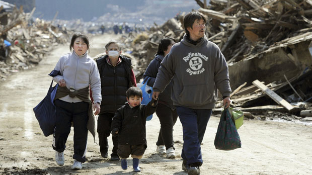 Japan crisis: family walks past devastation in Minamisanriku. (Reuters)