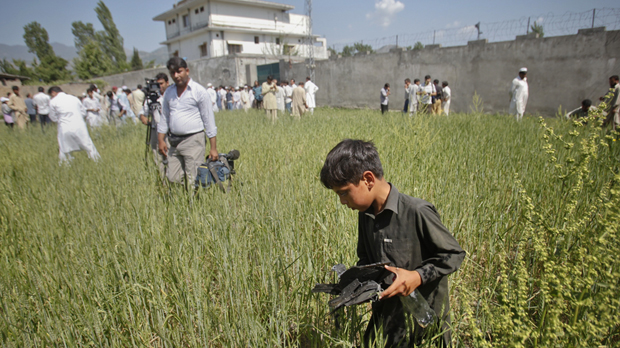 Abbottabad: a boy picks up debris close to bin Laden's former hideout. (Reuters)