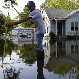 Mississippi floods: Arthur Burton measures encroaching water as floodwaters slowly rise in Memphis, Tennessee (Reuters)