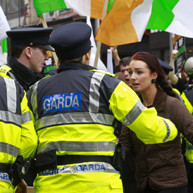 Members of the Irish police block a woman during a protest in Dublin (reuters)