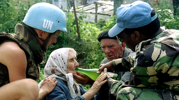 Dutch UN soldiers proffer a drink to a Bosnian Muslim woman in Srebrenica (Reuters)