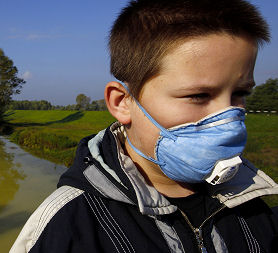 A boy wears a mask next to the Marcal River in Morichida, where a spill has killed fish (Reuters)