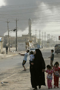 Iraq war files: a woman walks in Sadr City as a Hellfire explodes in the distance. (Reuters) 