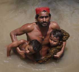 A father with his sons in the flood waters. (Reuters)