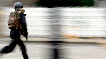 An armed officer running during the Mumbai attacks. (Getty)