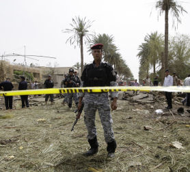 Iraqi security forces stand guard at the site of a bomb attack in Mansour District, Baghdad (credit:Reuters)