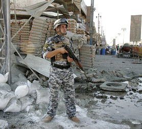 An Iraqi soldier guards the site of a bomb (Reuters)