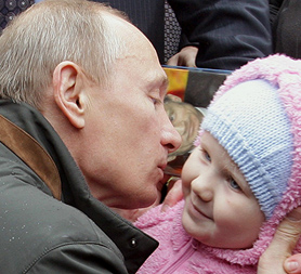 Russian Prime Minister Vladimir Putin kisses a baby on a recent trip; Russia is offering prizes to women who give brith on the Day of Conception (Image: Getty)
