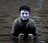 A boy puts cream on in his face during the Pakistan floods (Reuters)