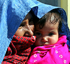 An Afghan villager woman holding her child comes to see the governor of Bamiyan province Habiba Sorabi (Reuters)