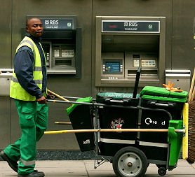 A council dustman passes a Royal Bank of Scotland branch in central London. (Getty images)