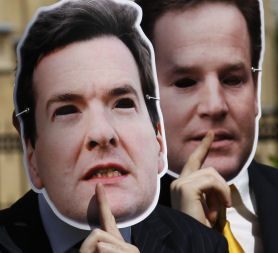 Demonstrators hold up improvised face masks after George Osborne presented his first budget (credit:Reuters)