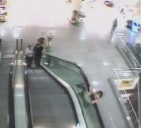 A Turksih four-year-old clings to the outside of an escalator. (Credit: Reuters)